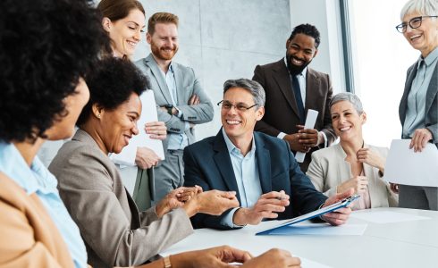 Group of young and senior business people having a meeting and signing a contract agreement in the office. Teamwork and success concept